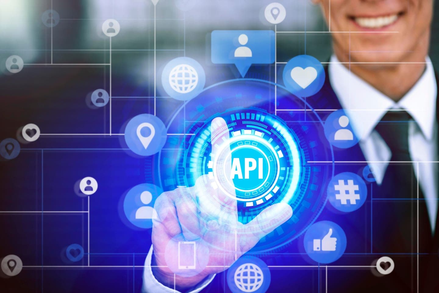 A man in a dark suit and tie reaches out to press a glowing cyan API button at the centre of a blue holographic network of user, globe and location icons.
